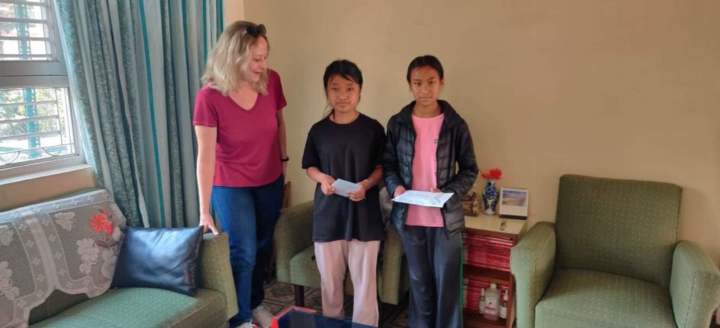 Fabienne Vionnet, membre du comité de l’Organisation Suisse Sagarmatha et deux enfants de Sagamatha.